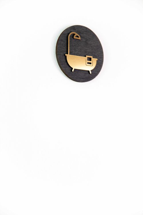 Detail of a black and gold coat hook on the white wall