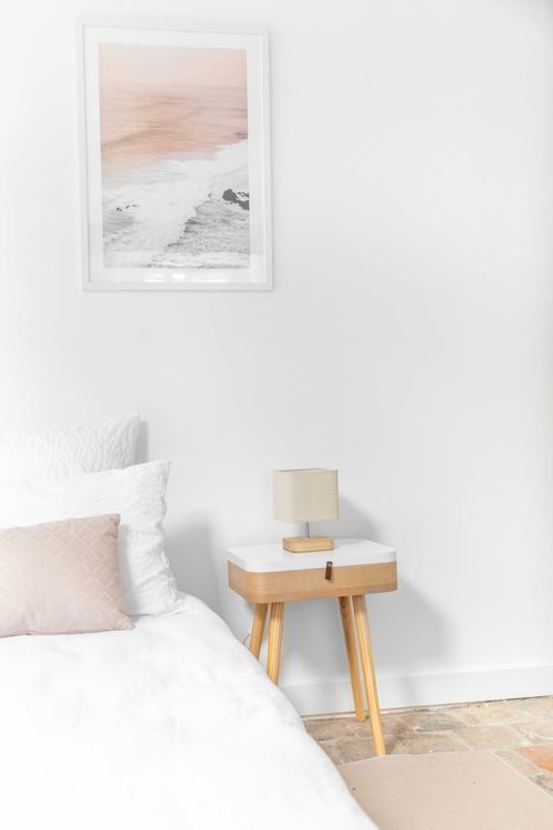 Detail of a single bed and wooden bedside table