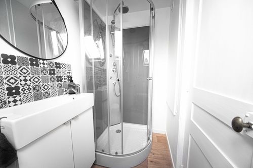 The shower room with a shower cubicle, basin and black-and-white patterned tiles