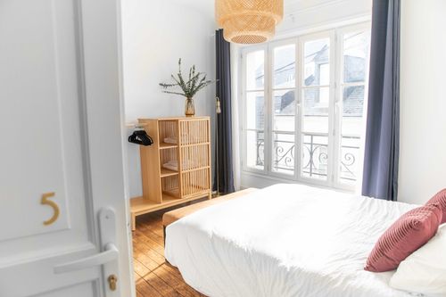 The fifth bedroom seen from the doorway, with a double bed and large window
