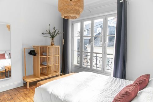 The double bedroom with red cushions and cane furniture near the window