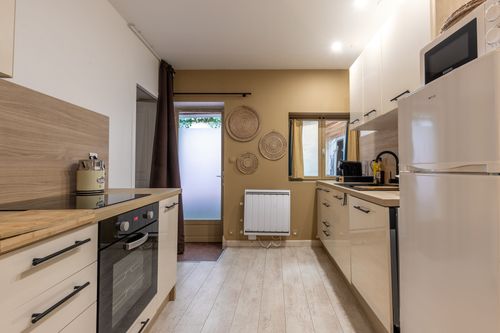 La Chambrée’s kitchen with an oven, refrigerator and wooden worktops