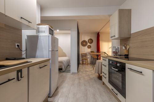 La Chambrée’s kitchen opening onto the dining area and glass-partitioned bedroom