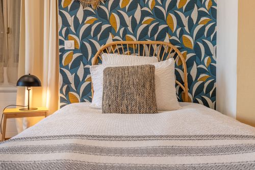 A single bed in La Chambrée against botanical wallpaper