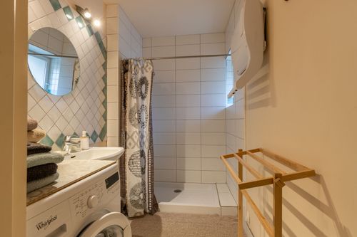 La Chambrée’s shower room with a shower, basin and washing machine