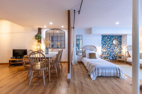 La Chambrée’s round table beside the single beds and TV area