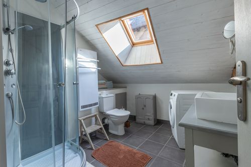 Le Loft’s attic shower room with a shower, basin and toilet