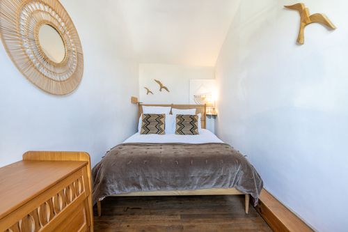 Le Loft’s double bedroom with a wooden desk and bird decorations