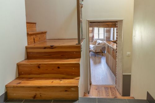 Le Loft’s wooden staircase and passage to a bedroom