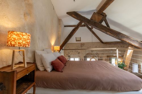 Le Loft’s mezzanine double bed beneath exposed roof timbers