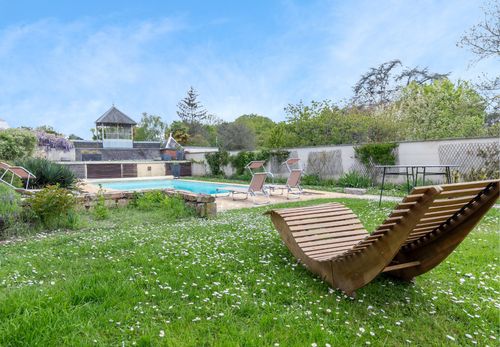 Wooden sun loungers in the garden facing the pool