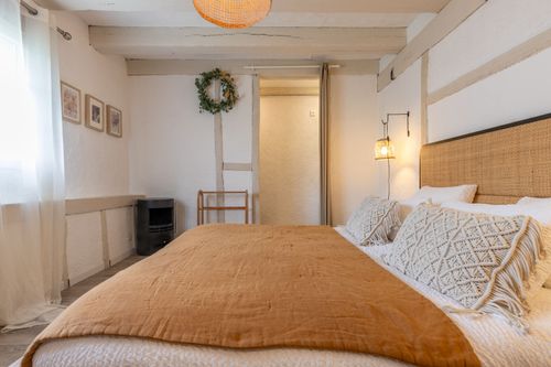 The bedroom with an ochre bedspread and cane headboard