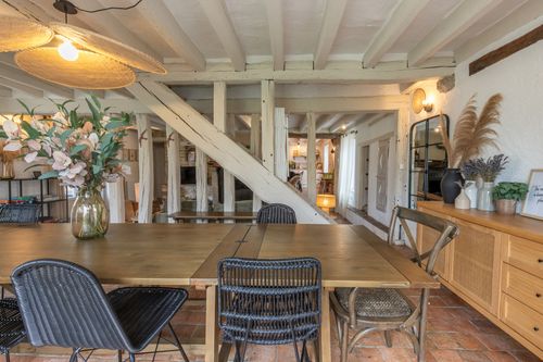 The large dining table beside the sideboard and staircase