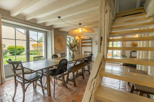 The dining room opening onto the garden through wide glass doors