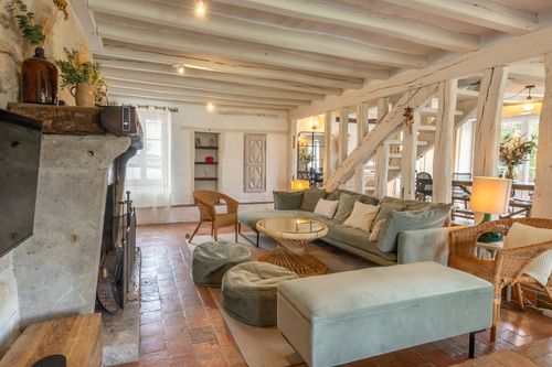 Le Cottage’s lounge with a green sofa, fireplace and round coffee table