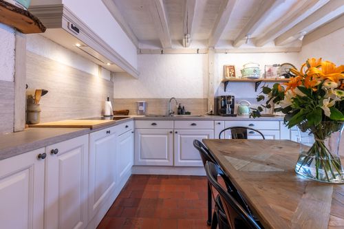 The kitchen worktops and flower-decorated table beneath the beams