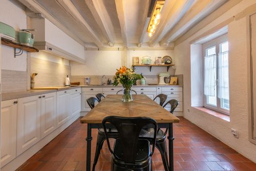 Le Cottage’s kitchen with a wooden table, black chairs and white beams