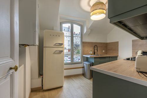 The kitchen entrance with a cream refrigerator and green cabinets