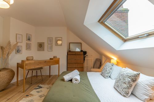 The attic bedroom with a double bed, desk and wooden chest of drawers