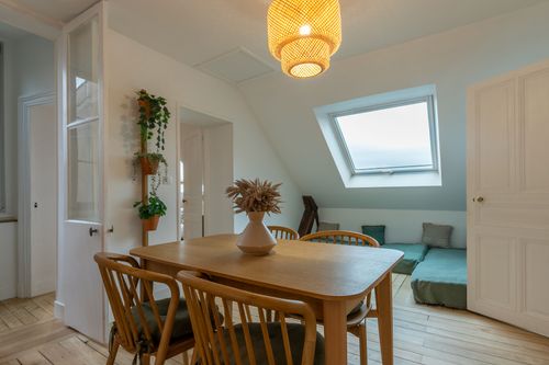 The wooden dining area beneath the eaves, near the roof window