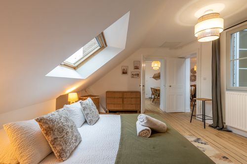 The double bed facing the chest of drawers and attic bedroom door