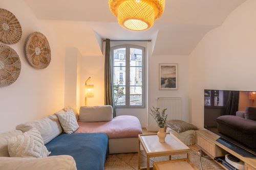 The lounge with a corner sofa, coffee table and natural-fibre pendant lights