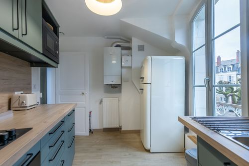 The equipped kitchen with wooden worktops and a window over the rooftops