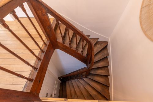 The turning wooden staircase leading to the apartment landing