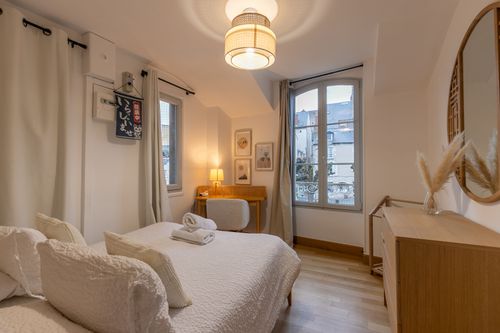 The second bedroom with a double bed, chest of drawers and two windows