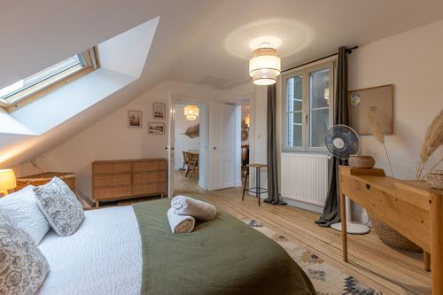 The attic bedroom with a double bed, desk and window overlooking the town