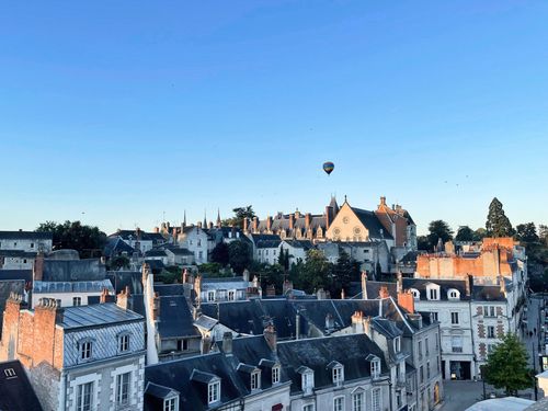 A hot-air balloon above the castle and rooftops of Blois