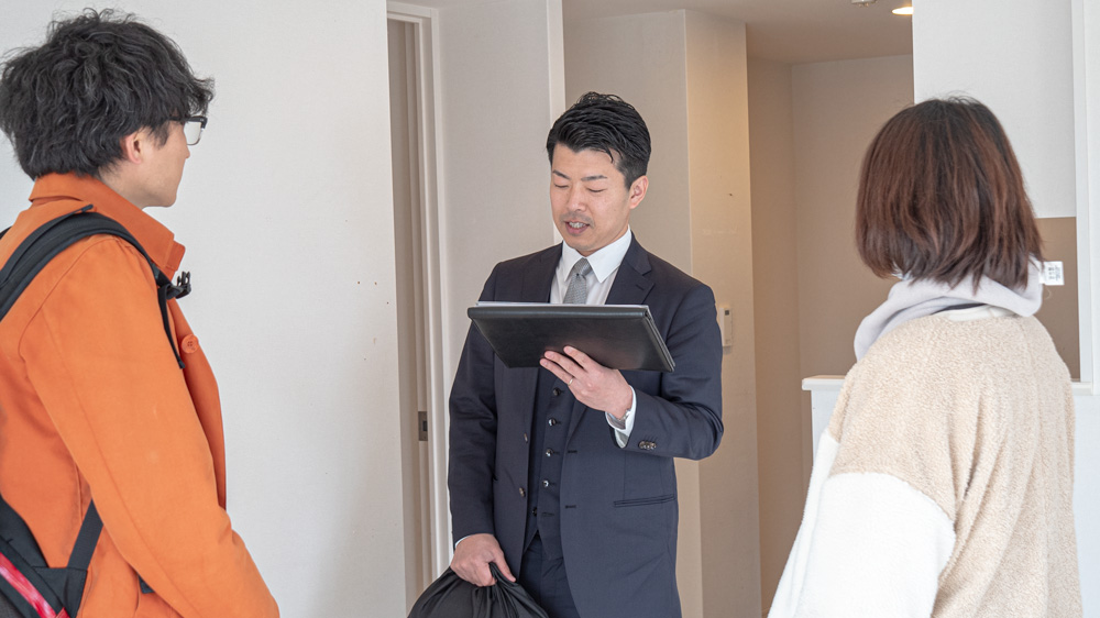 参加者に資料を見せながら説明する平山