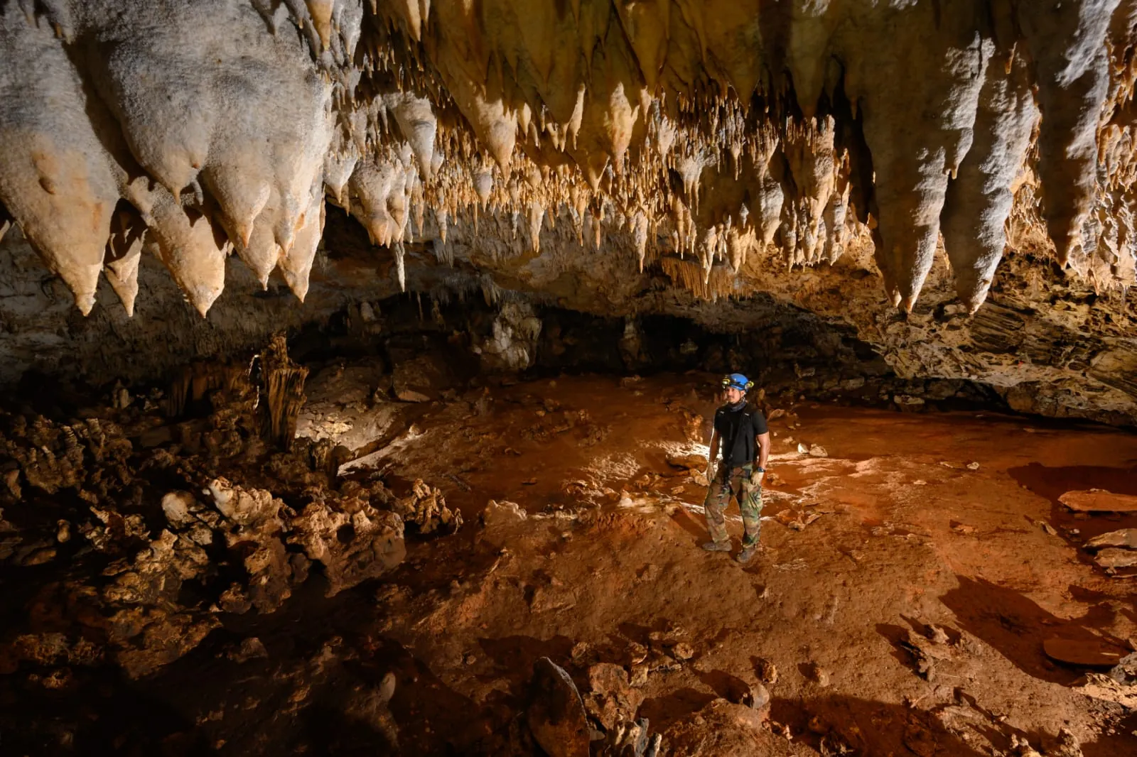 Explorer beneath stalactites in Actun Tunichil Muknal cave, Belize