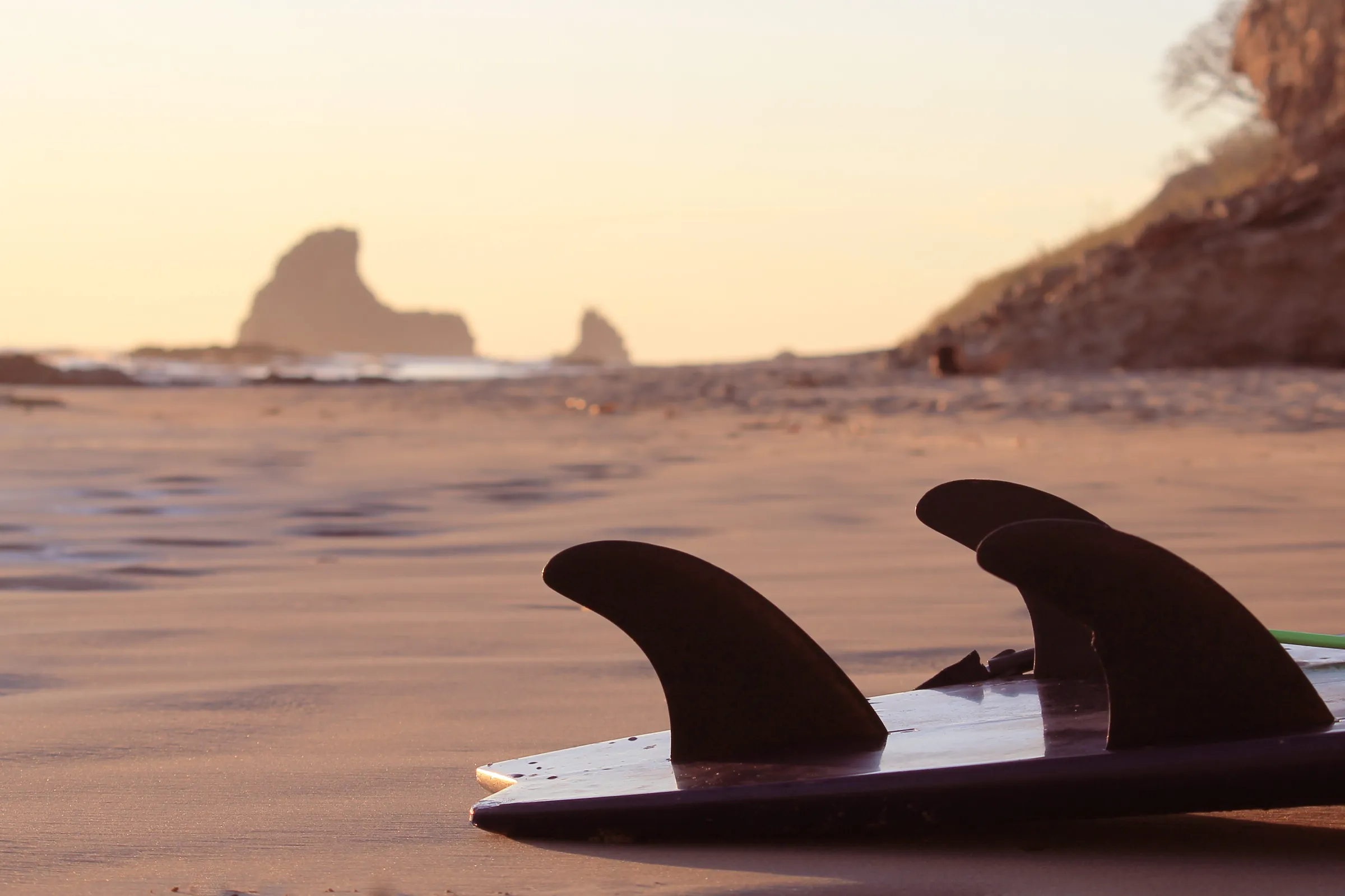 Surfboard fins on the sand at sunset, Nicaragua