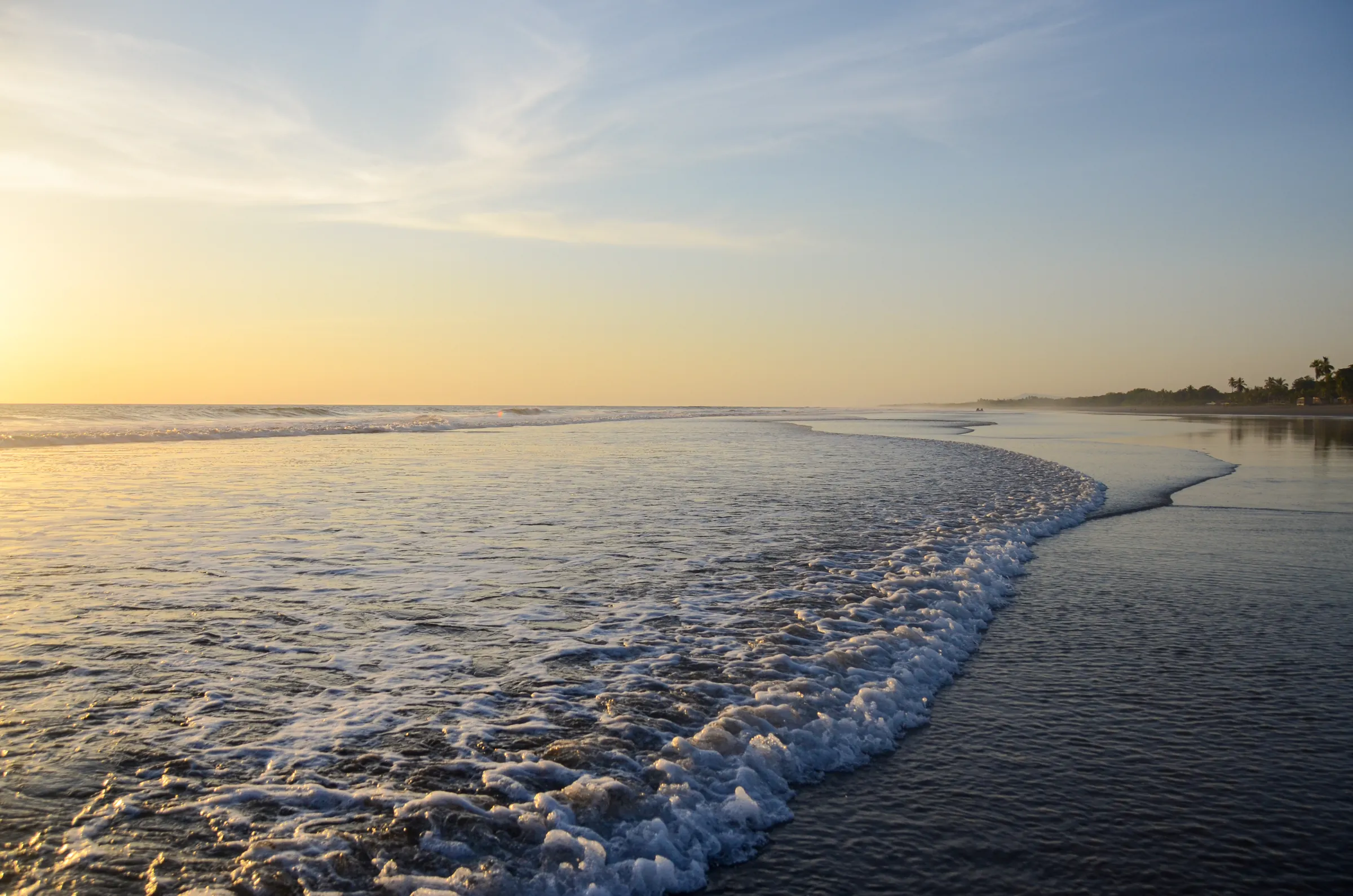 Golden sunset over gentle waves on a long Pacific beach, Nicaragua