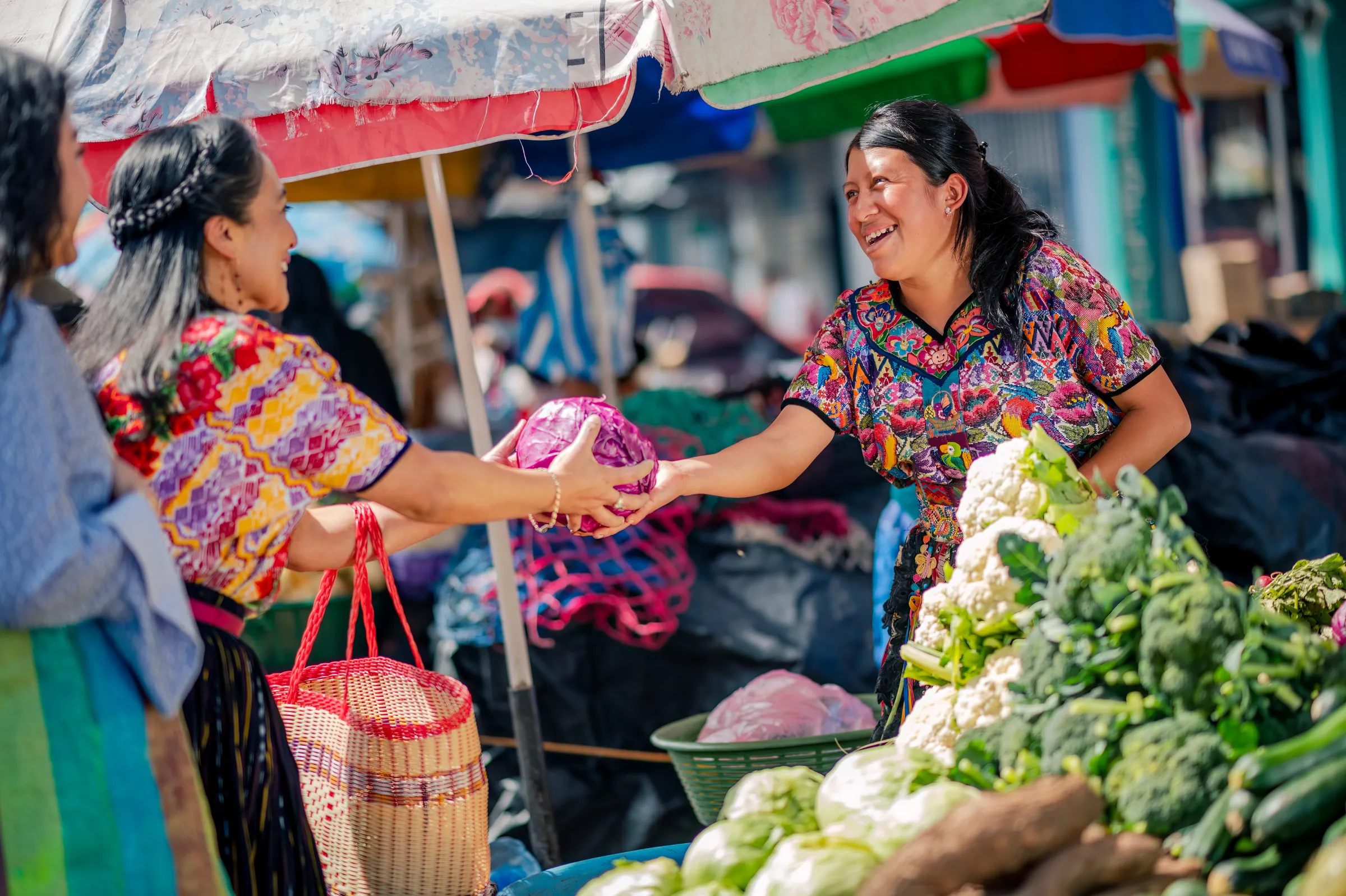 Vendors exchanging produce at a market in Guatemala.