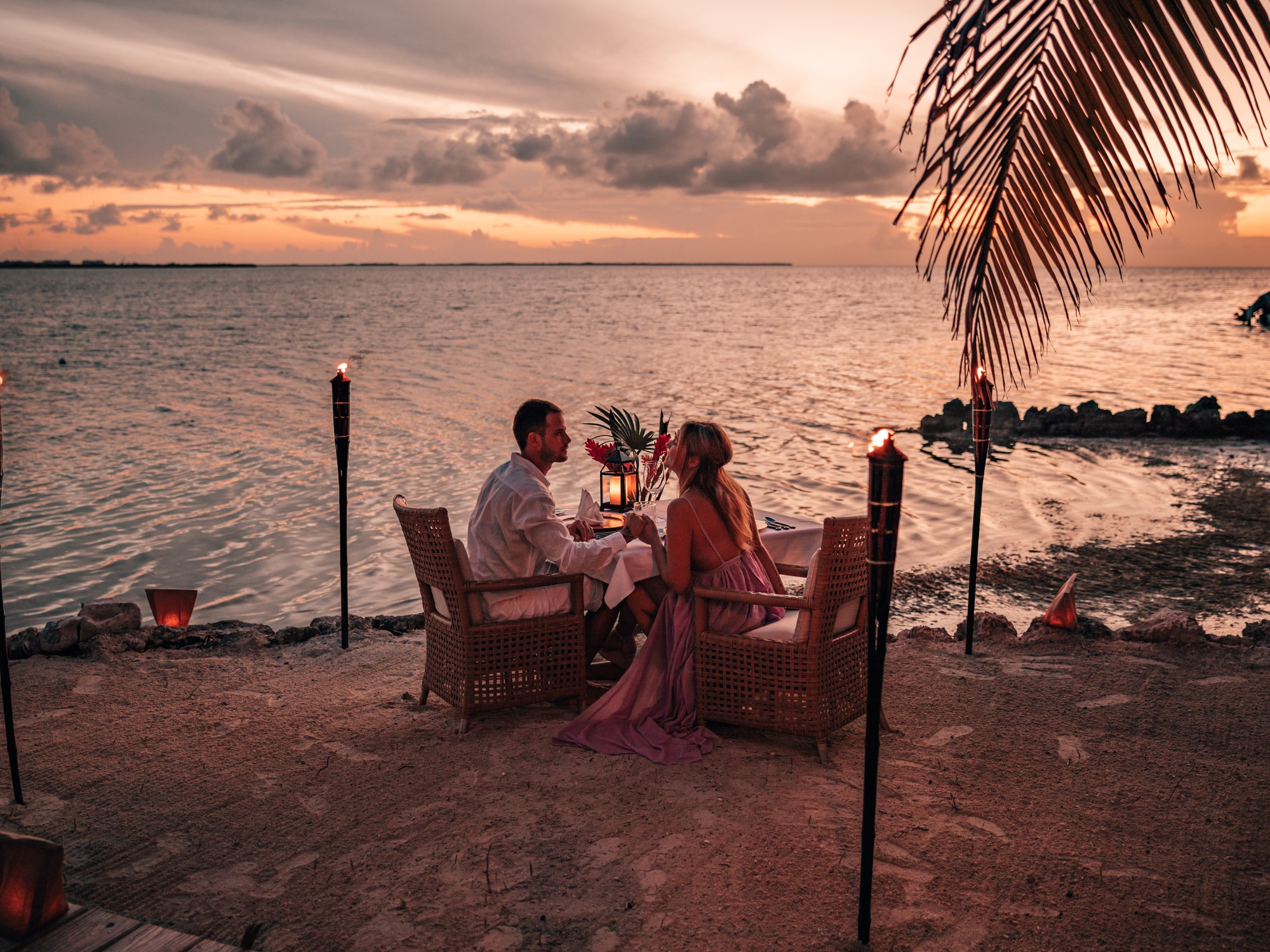 Candlelit beach dinner at sunset on Cayo Espanto, Belize