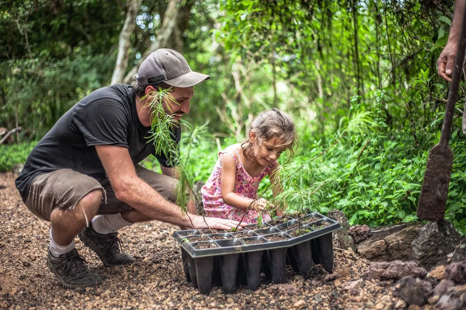 A traveler and child planting native trees in the Galápagos.