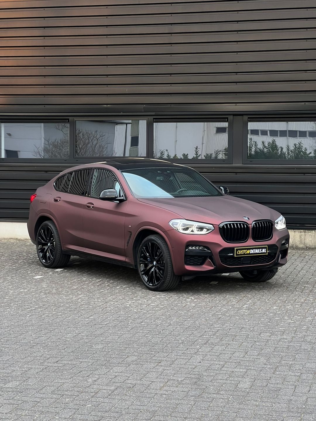 BMW X4 in satijn bordeauxrood met zwarte velgen