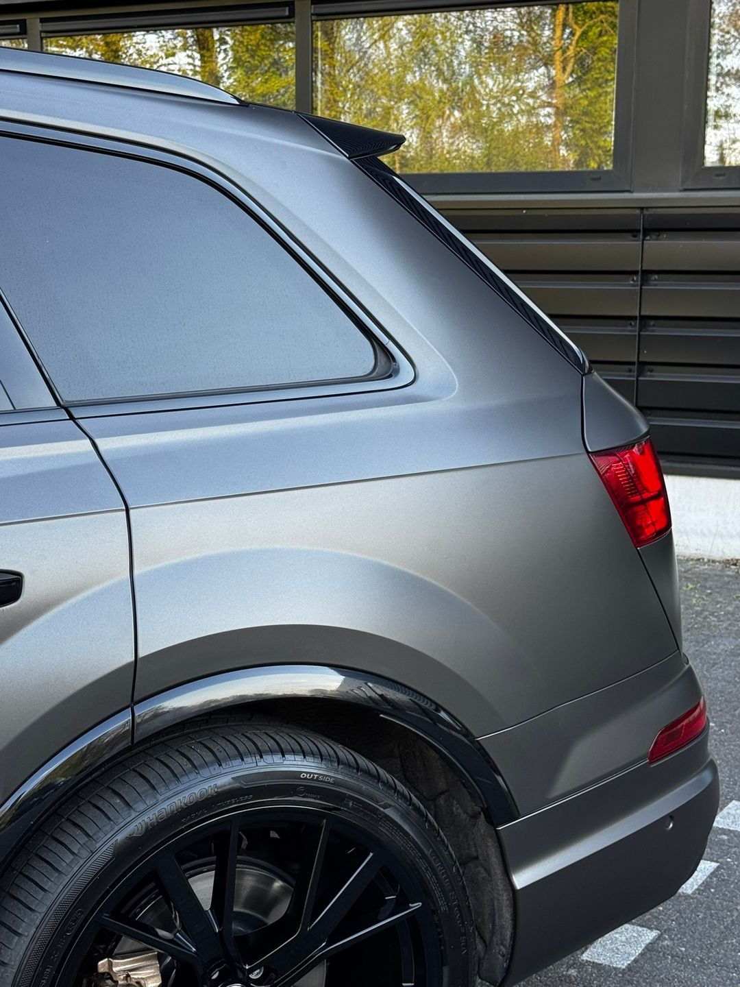 Close-up van strak afgewerkte wrapranden rond wielkast en achterlicht van een Audi Q7