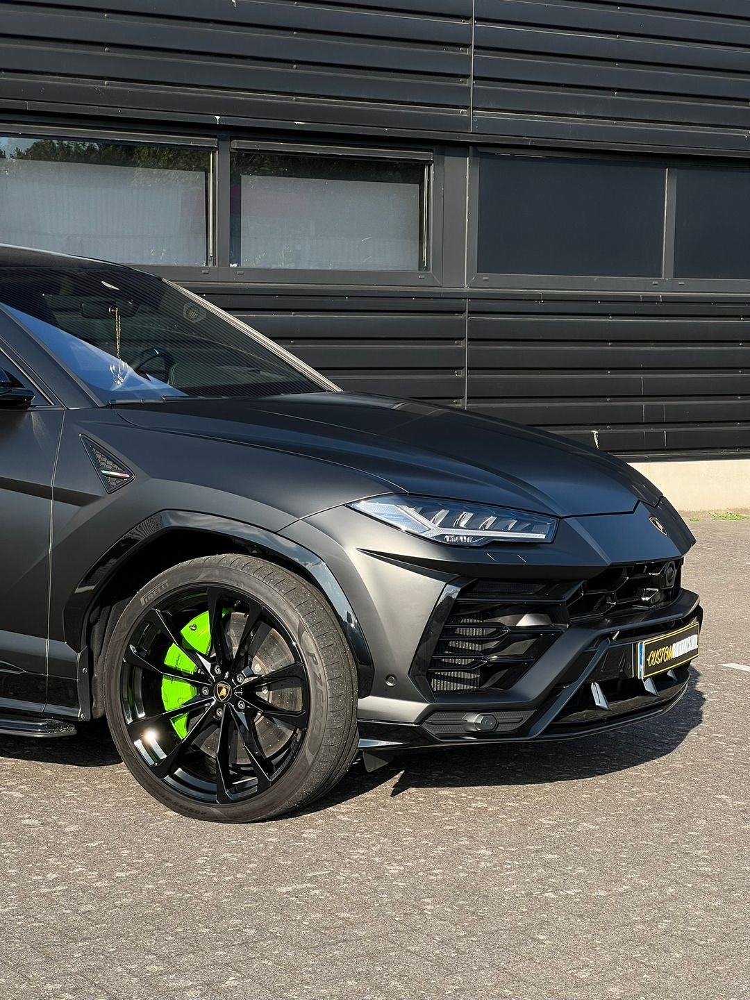 Close-up van groene remklauwen en zwarte velg van een Lamborghini Urus