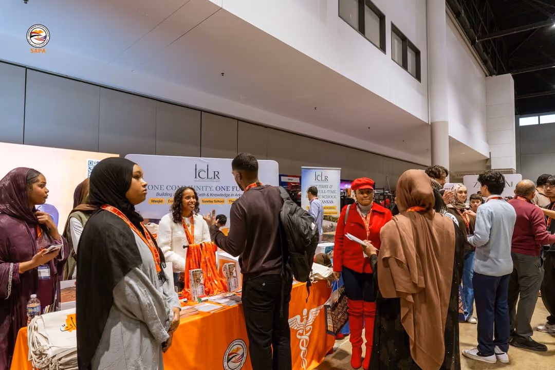 Branded exhibitor booth with orange table cover and lanyards
