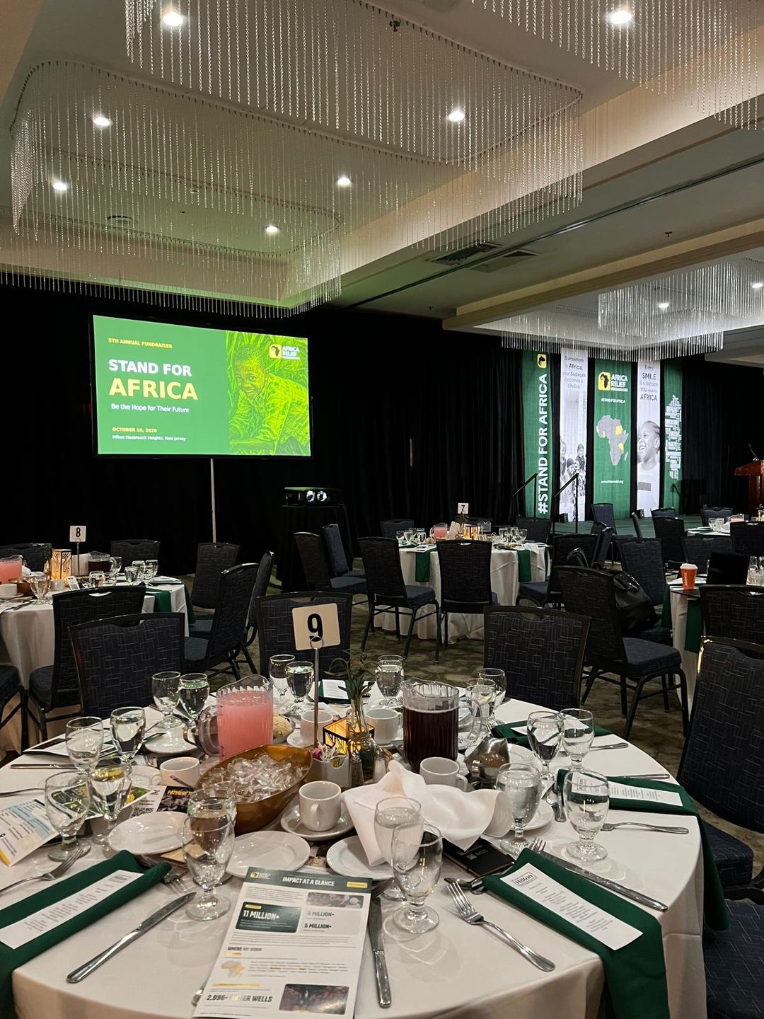 Ballroom with table settings, programme screen and branded stage