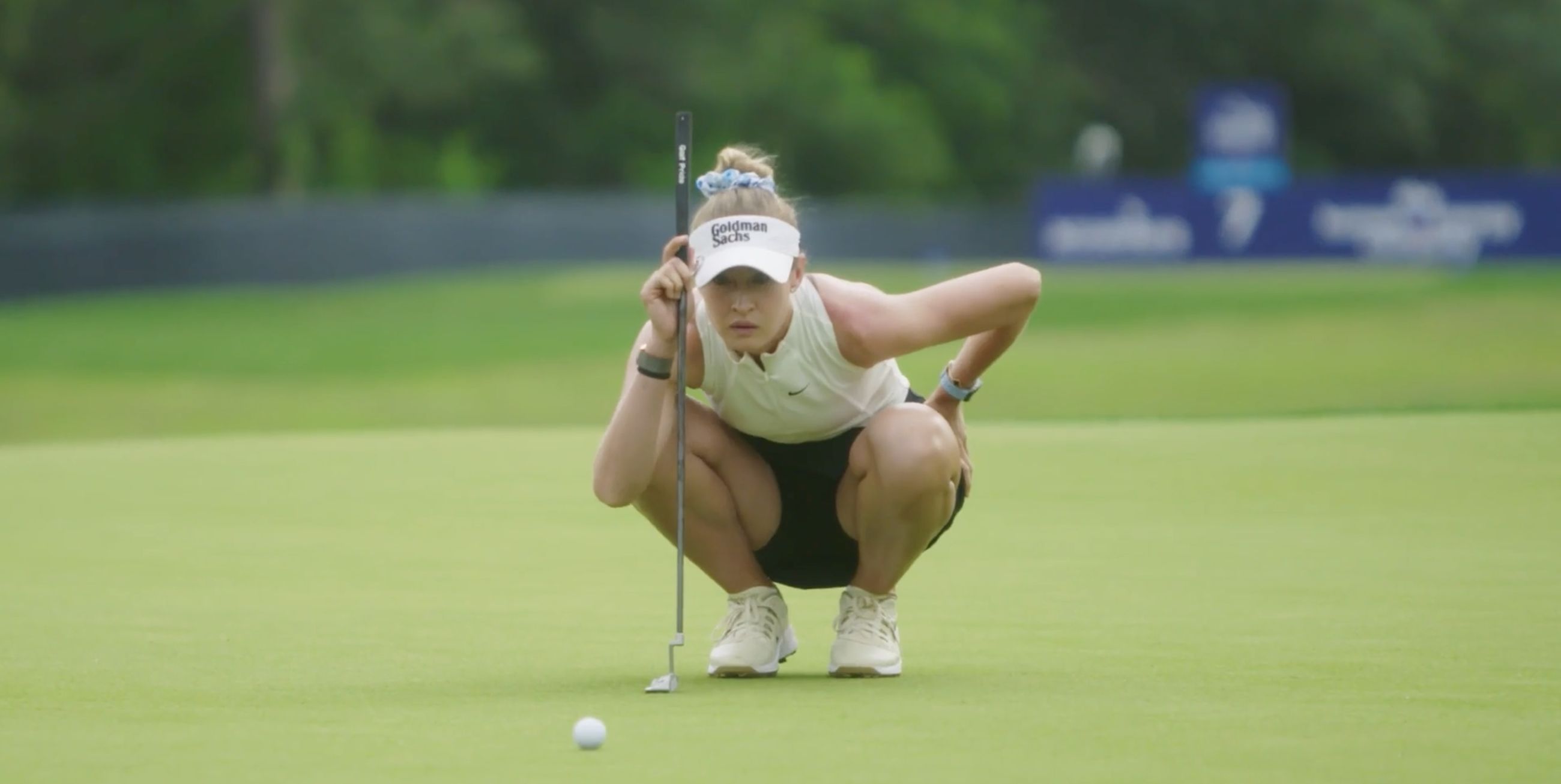 Nelly Korda crouched over a putt, reading the line, during the Chevron Championship