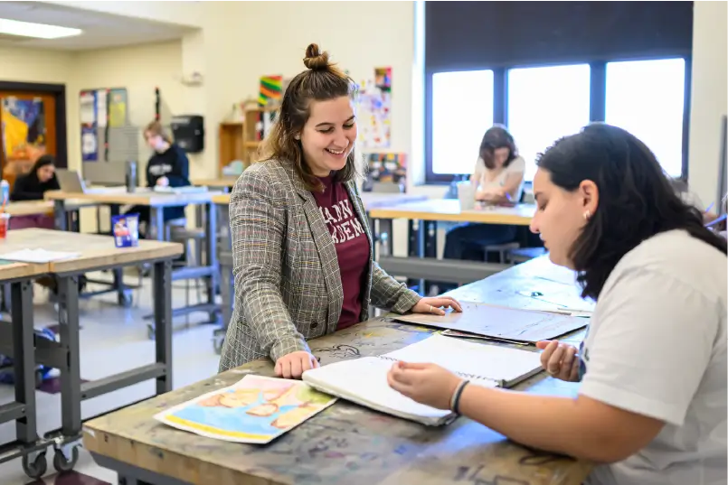 Student working with teacher in arts studio class