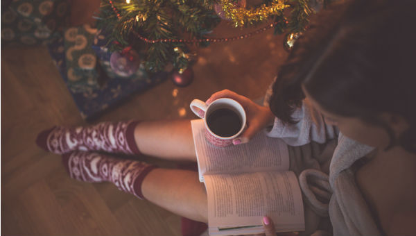 woman reads book at Christmass tree 600 x 340.jpg