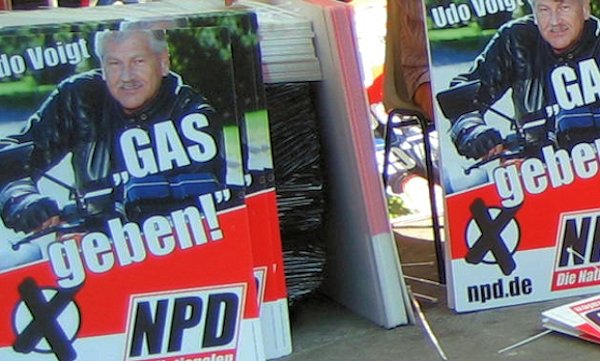 Former NPD leader Udo Voigt with a campaign poster saying 'Give gas'