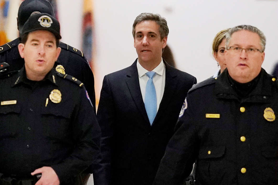 Michael Cohen, the former personal attorney of President Trump, is escorted by Capitol Hill police officers as he arrives to testify at a House Committee on Oversight and Reform hearing on Wednesday
