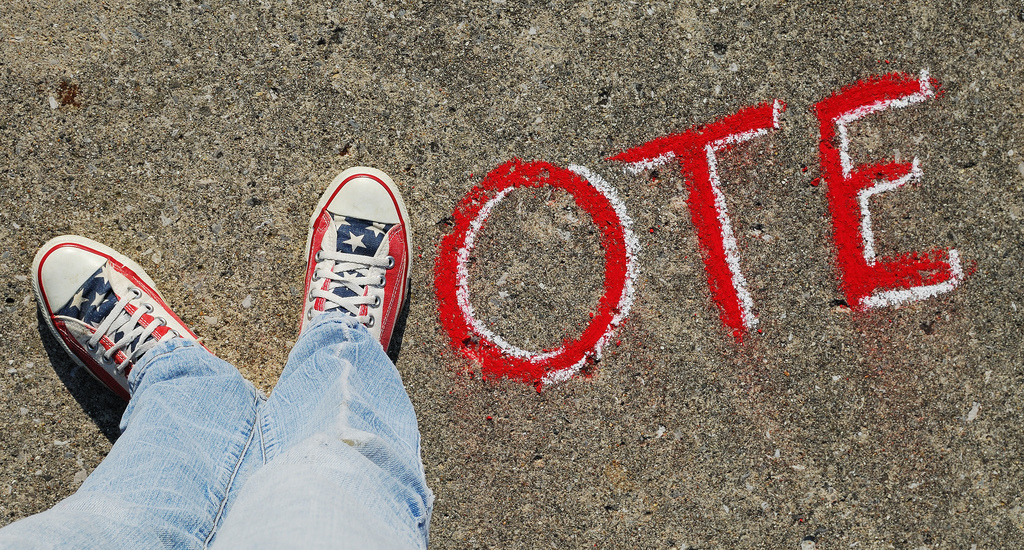 Picture of a person's feet in the shape of the letter V, followed by O T E to spell vote.