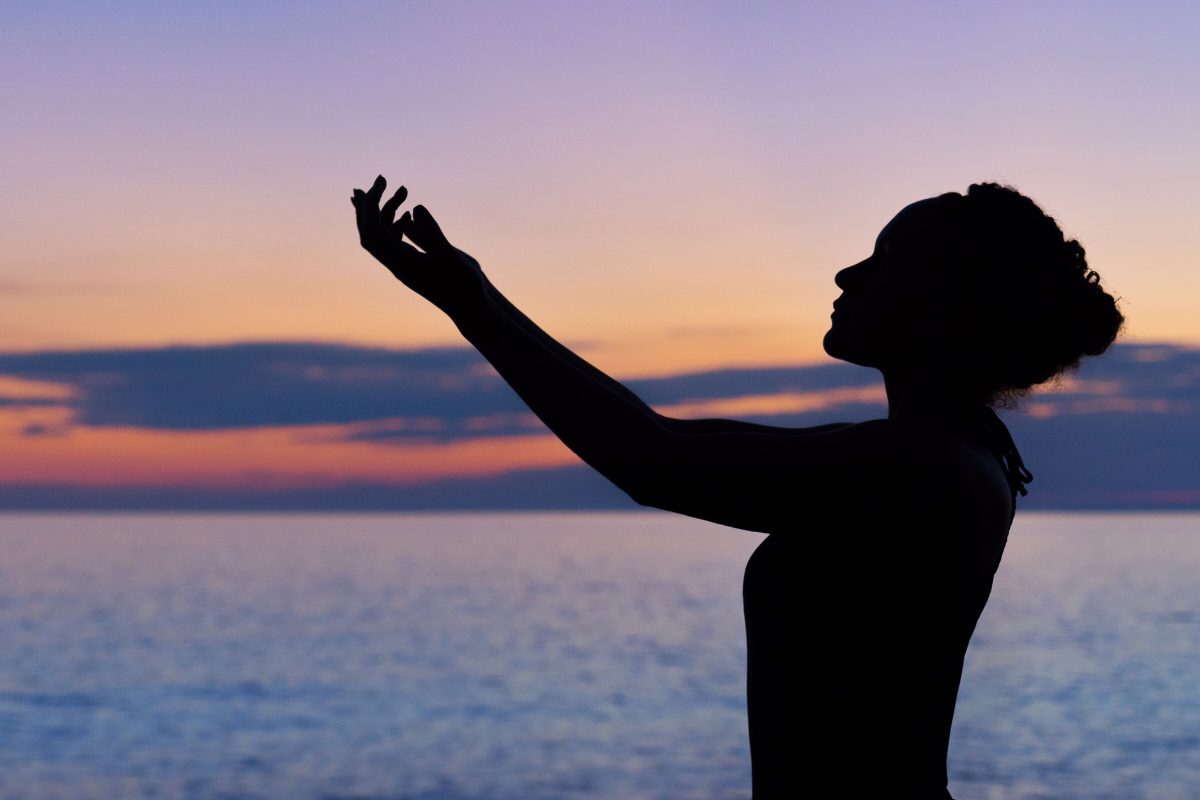 Woman raising arms on a beach